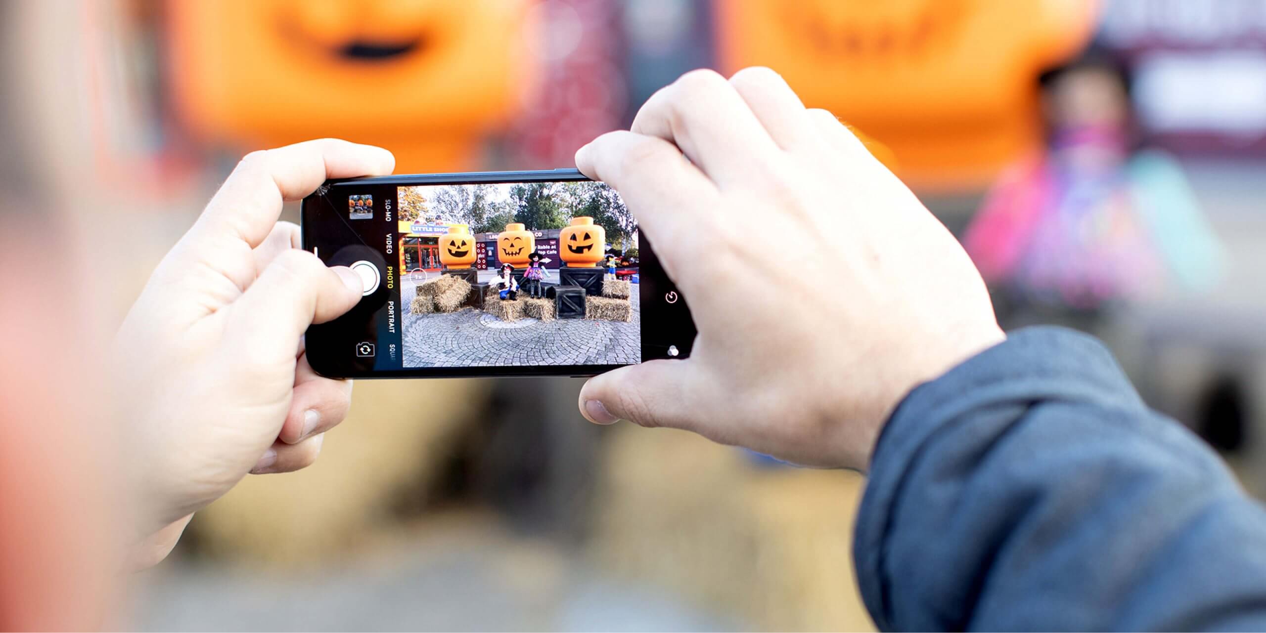 Man holding a phone taking a picture of Brick or Treat attraction